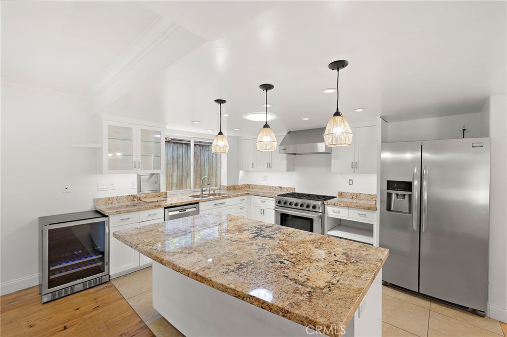 273 Cecil Place Costa Mesa, CA 92627 - Photo 7 of 18 a kitchen with stainless steel appliances granite countertop a sink stove and refrigerator