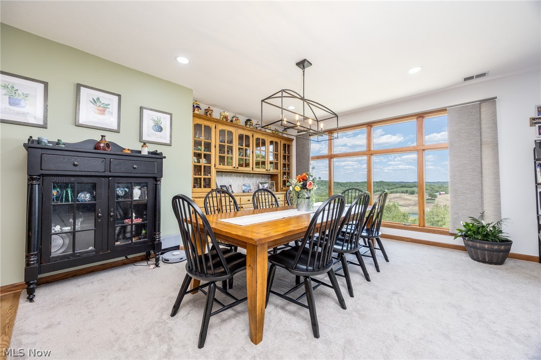 1602 Glendale Road, Unit 3 Marietta, OH 45750 - Photo 11 of 49 Dining area featuring expansive windows, a coffered ceiling light fixture, light-colored carpeting, a built-in wooden display cabinet, and recessed ceiling lighting