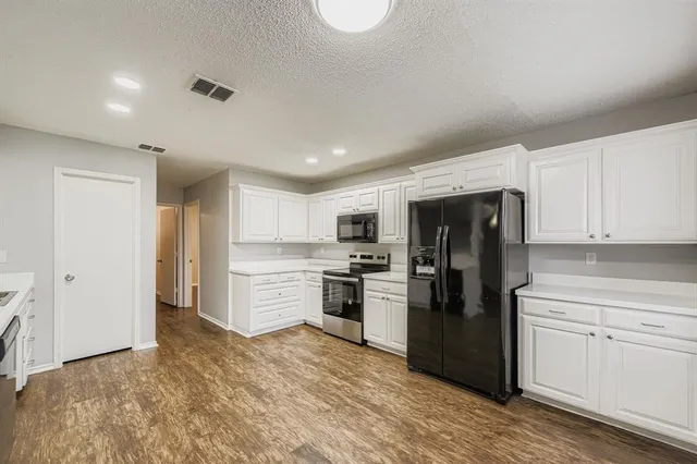 a kitchen with a refrigerator stove top oven and sink