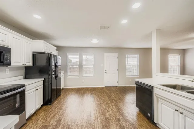 a view of kitchen with wooden floor and electronic appliances