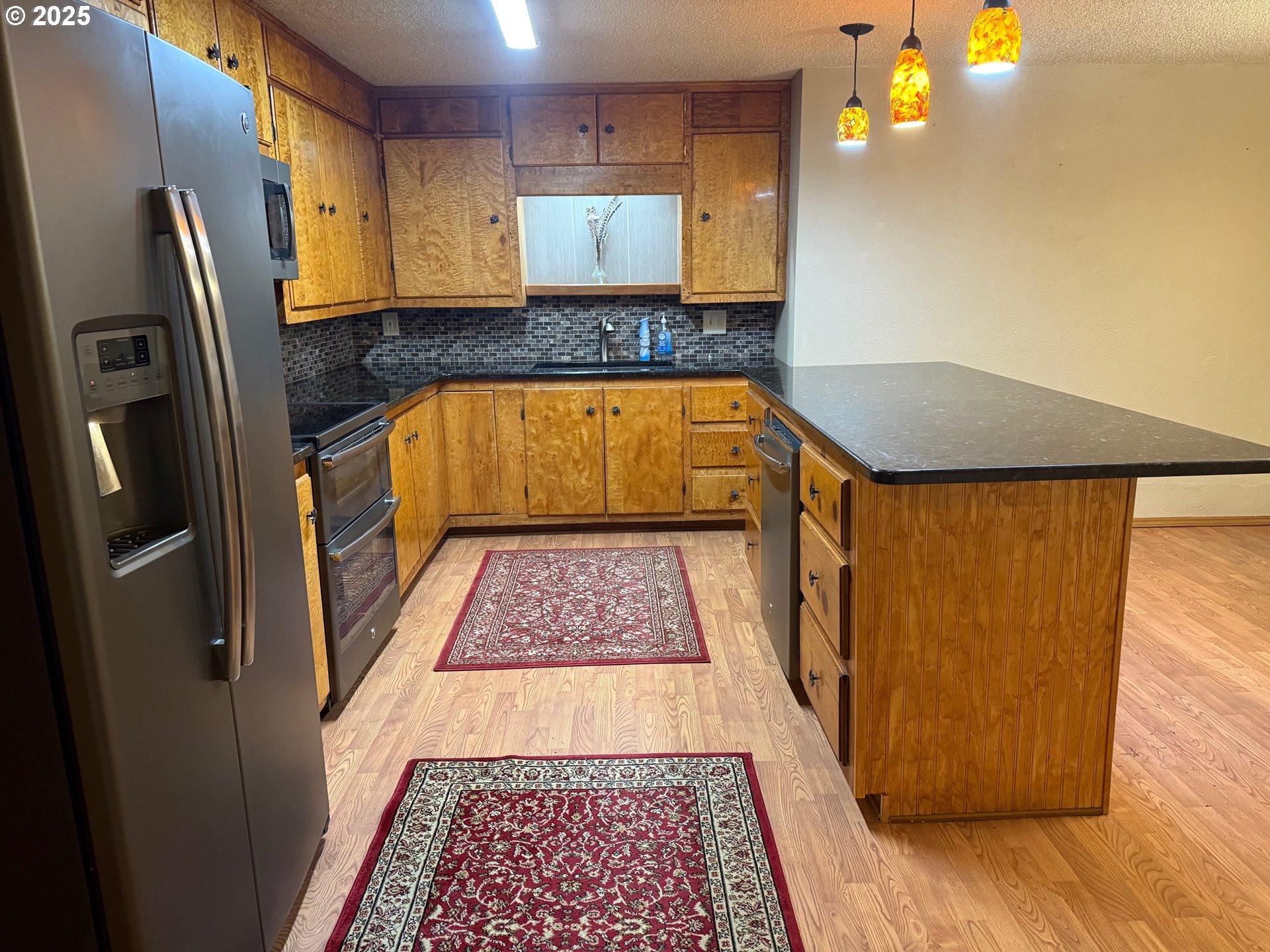 87511 Tiernan Road Mapleton, OR 97453 - Photo 5 of 23 a view of a kitchen with wooden floor and a refrigerator