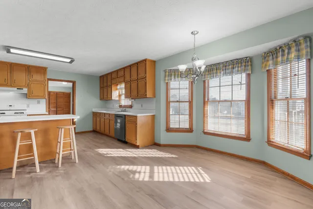a view of a kitchen with furniture a rug and wooden floor