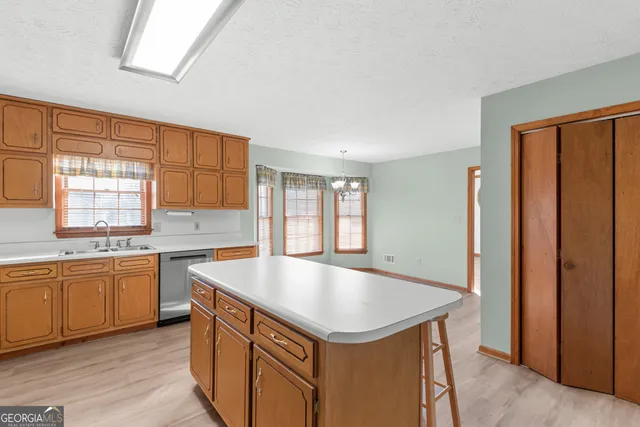 a kitchen with stainless steel appliances granite countertop a sink and dishwasher a refrigerator with wooden cabinets