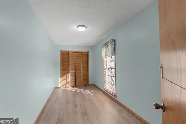 an empty room with windows and closet