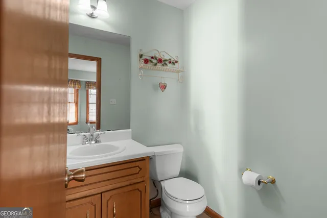 a bathroom with a sink a toilet and mirror