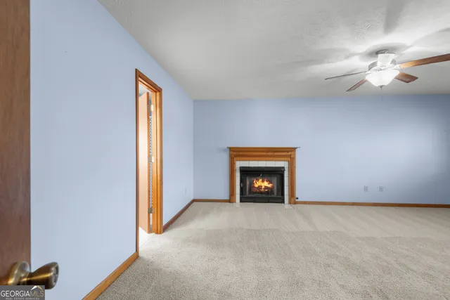 an empty room with windows and fireplace