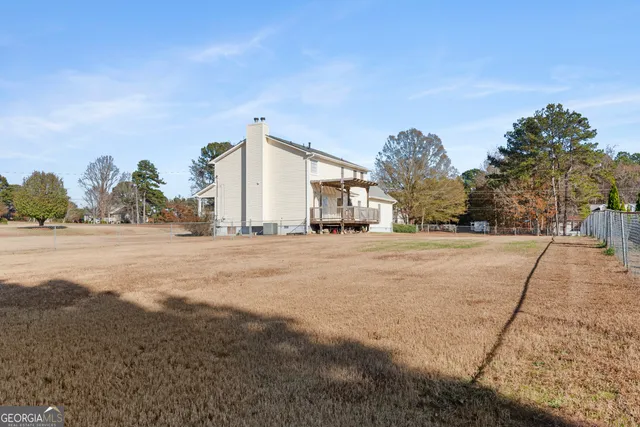 a view of a house with a yard and fence