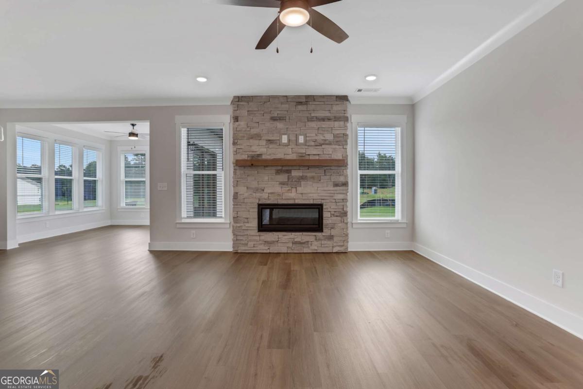 4230 Mary Ruth Way Loganville, GA 30052 - Photo 11 of 51 an empty room with wooden floor a fireplace and windows