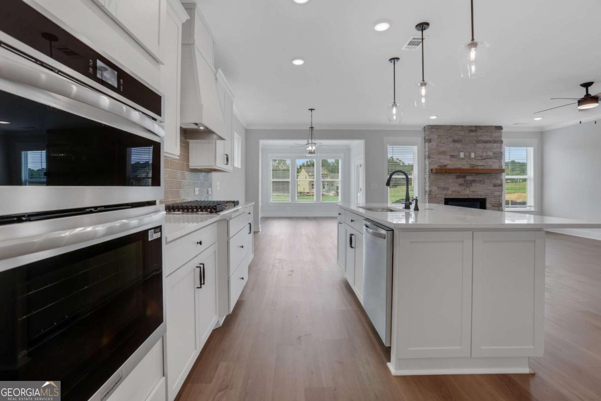 4230 Mary Ruth Way Loganville, GA 30052 - Photo 15 of 51 a large kitchen with stainless steel appliances kitchen island granite countertop a stove a sink and a microwave