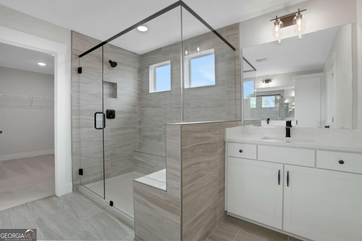 4230 Mary Ruth Way Loganville, GA 30052 - Photo 34 of 51 a bathroom with a shower sink and mirror