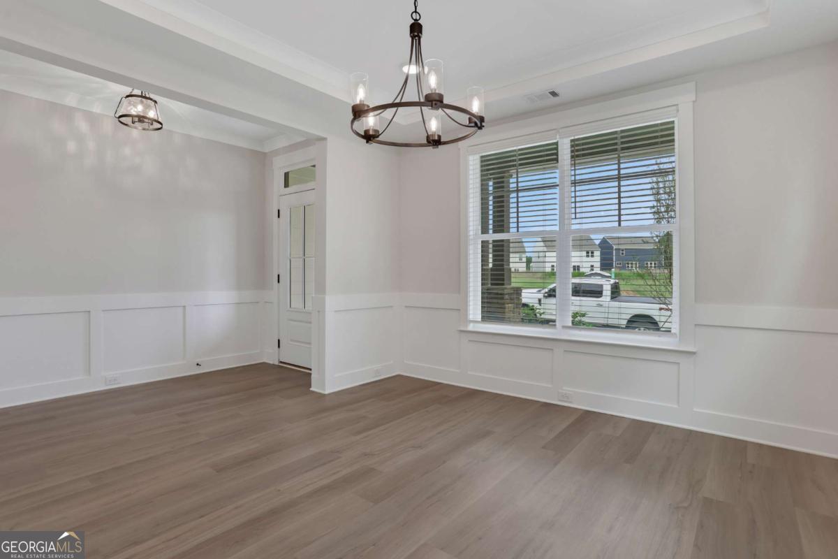 4230 Mary Ruth Way Loganville, GA 30052 - Photo 5 of 51 an empty room with wooden floor fan and windows