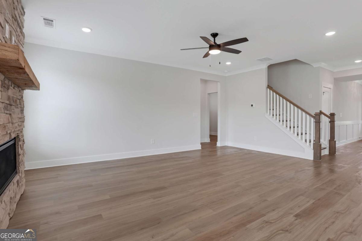 4230 Mary Ruth Way Loganville, GA 30052 - Photo 8 of 51 a view of an empty room with wooden floor and a ceiling fan