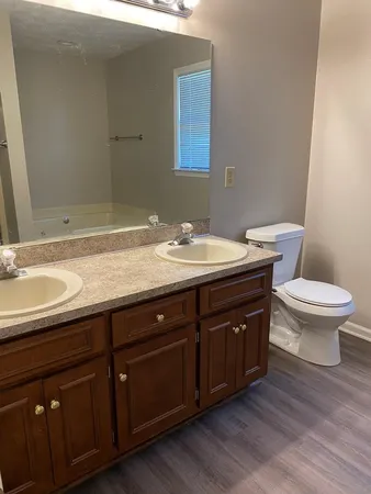 a bathroom with a granite countertop sink and a toilet