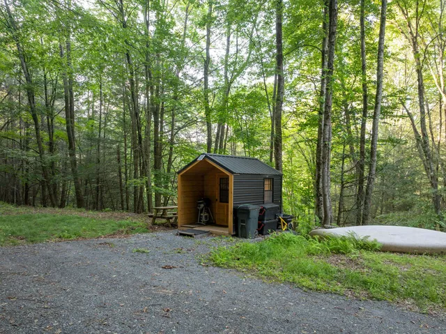 a view of a house with a yard and large trees