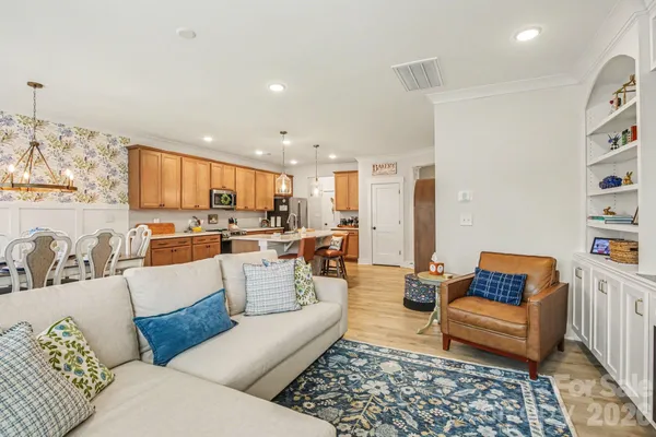 a living room with furniture kitchen view and a window
