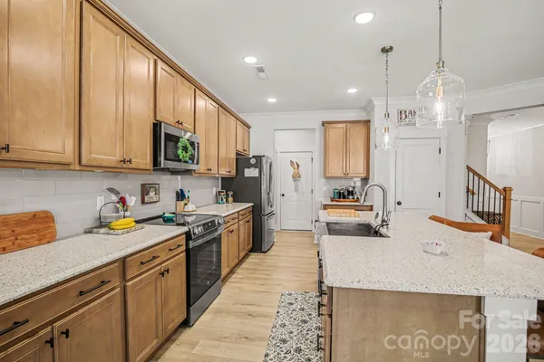 a kitchen with stainless steel appliances granite countertop a sink stove and refrigerator