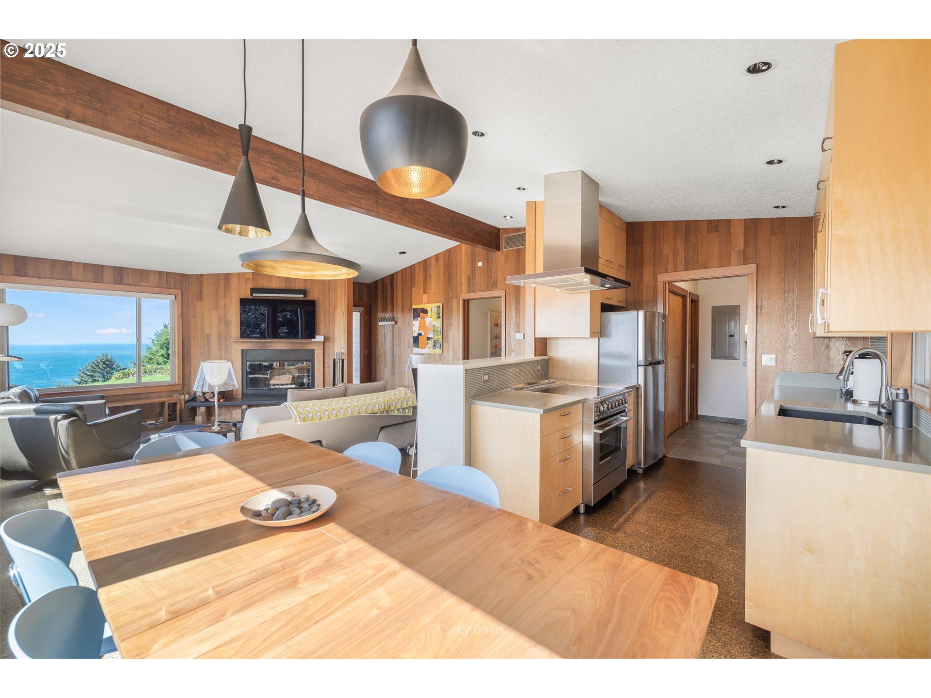 8455 San Dune Road Nehalem, OR 97131 - Photo 19 of 48 a kitchen with stainless steel appliances kitchen island granite countertop a sink dishwasher a stove and a dining table with wooden floor