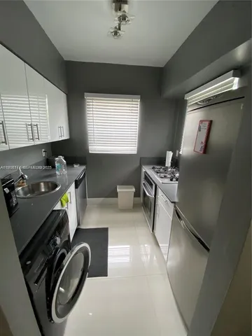 a kitchen with stainless steel appliances granite countertop a sink stove and a refrigerator