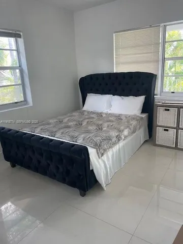 a room with a bed dresser and a window