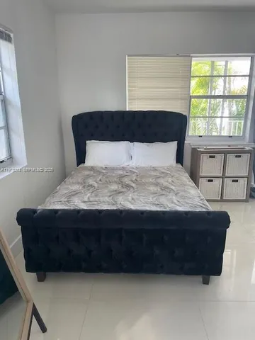 a bed sitting in a bedroom next to a window