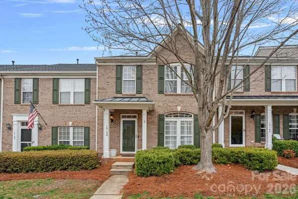front view of a brick house with a yard