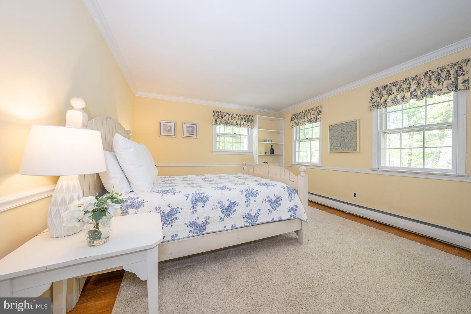 340 Chester Road Devon, PA 19333 - Photo 34 of 48 a spacious bedroom with a bed table and a lamp