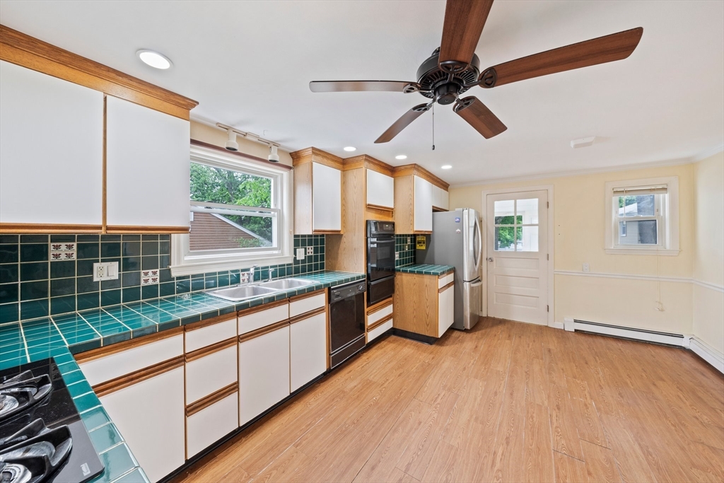 26 Sherman Road Braintree, MA 02184 - Photo 12 of 42 a kitchen with stainless steel appliances kitchen island granite countertop a stove a refrigerator and a wooden cabinets