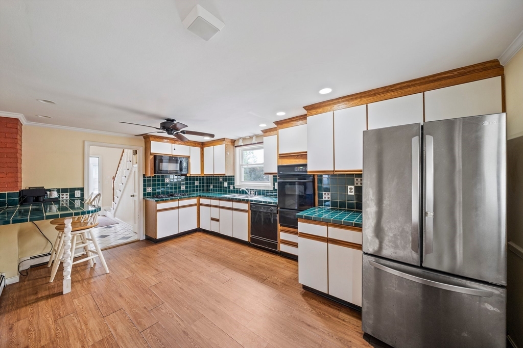 26 Sherman Road Braintree, MA 02184 - Photo 15 of 42 a kitchen with stainless steel appliances a refrigerator a stove a sink dishwasher and white cabinets with wooden floor