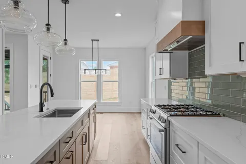 a kitchen that has a sink a stove and a window