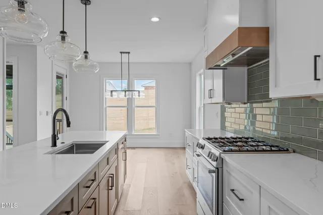 a kitchen that has a sink a stove and a window