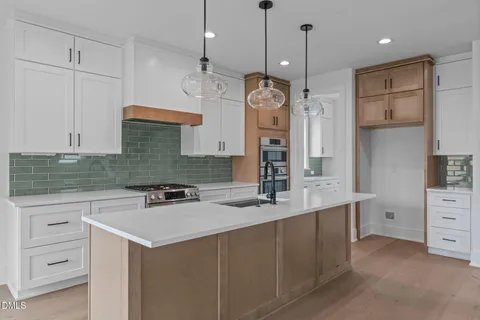 a large kitchen with stainless steel appliances granite countertop a sink a oven a refrigerator and a granite counter tops