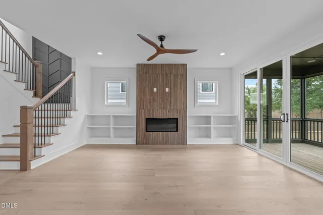 a view of an empty room with wooden floor and cabinet