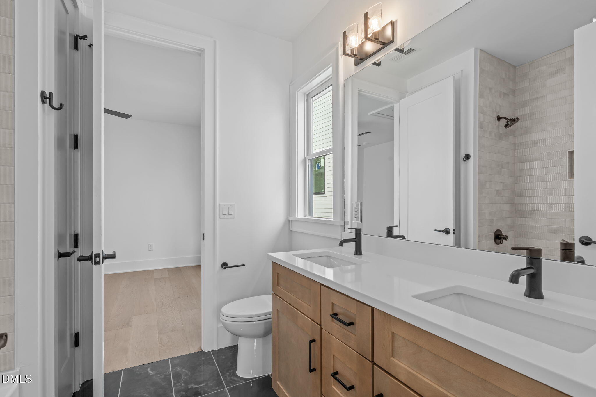 1012 Addison Place Raleigh, NC 27610 - Photo 32 of 56 a bathroom with a double vanity sink toilet and shower