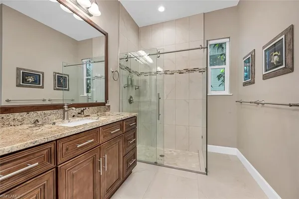 a bathroom with a shower sink vanity and mirror