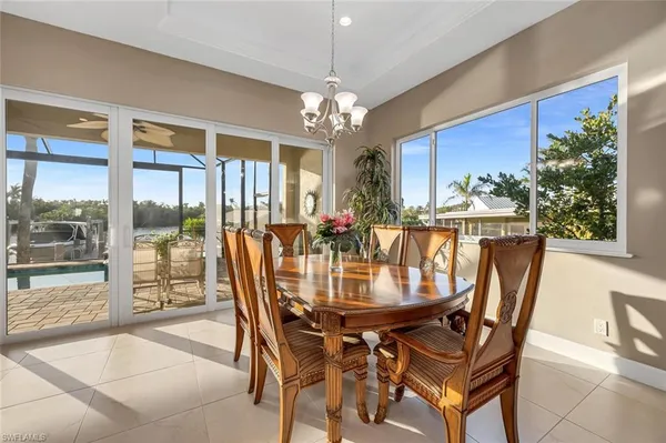 a dining room with furniture a chandelier and wooden floor