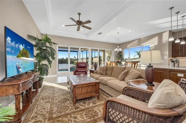 a living room with furniture a chandelier and a flat screen tv