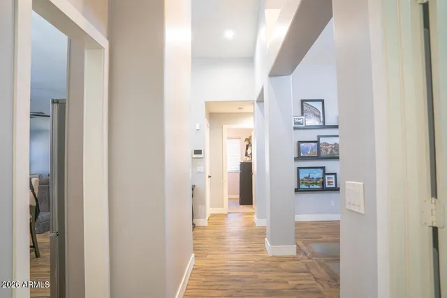 a view of a hallway with wooden floor and a bathroom