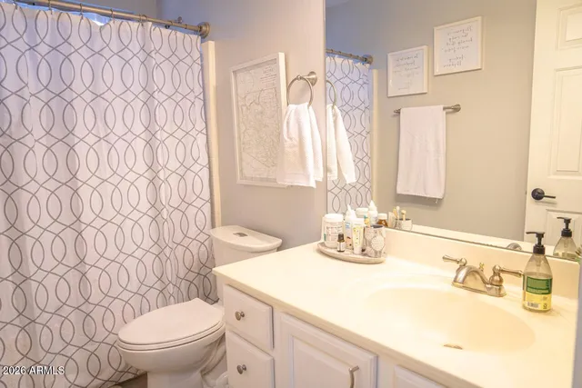 a bathroom with a granite countertop sink a toilet and a mirror