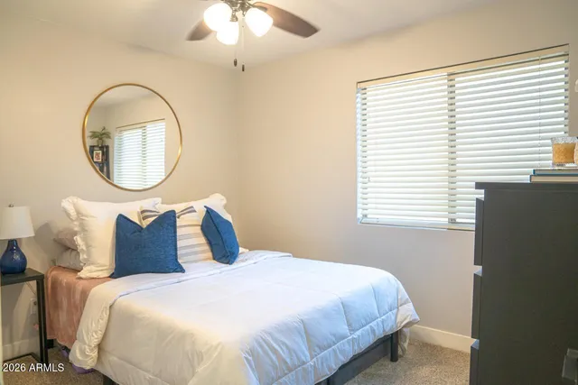 a bedroom with a bed and a large window