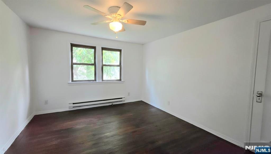 592 Beverly Road, Unit 2 Teaneck, NJ 07666 - Photo 5 of 7 an empty room with wooden floor fan and windows