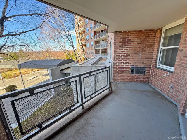 a view of an empty room with wooden floor and windows