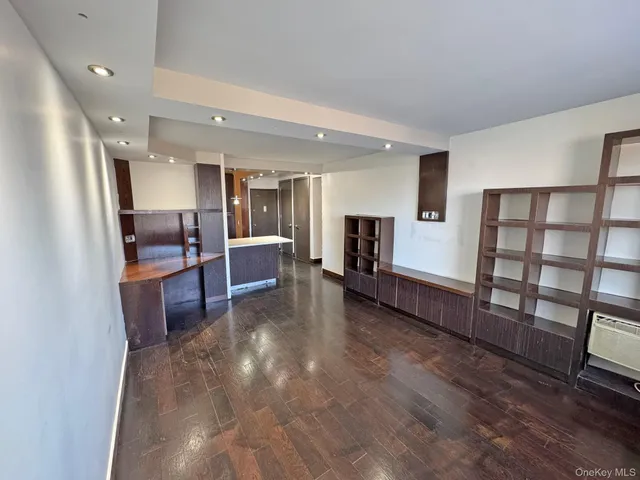 a view of a big room with kitchen view and wooden floor