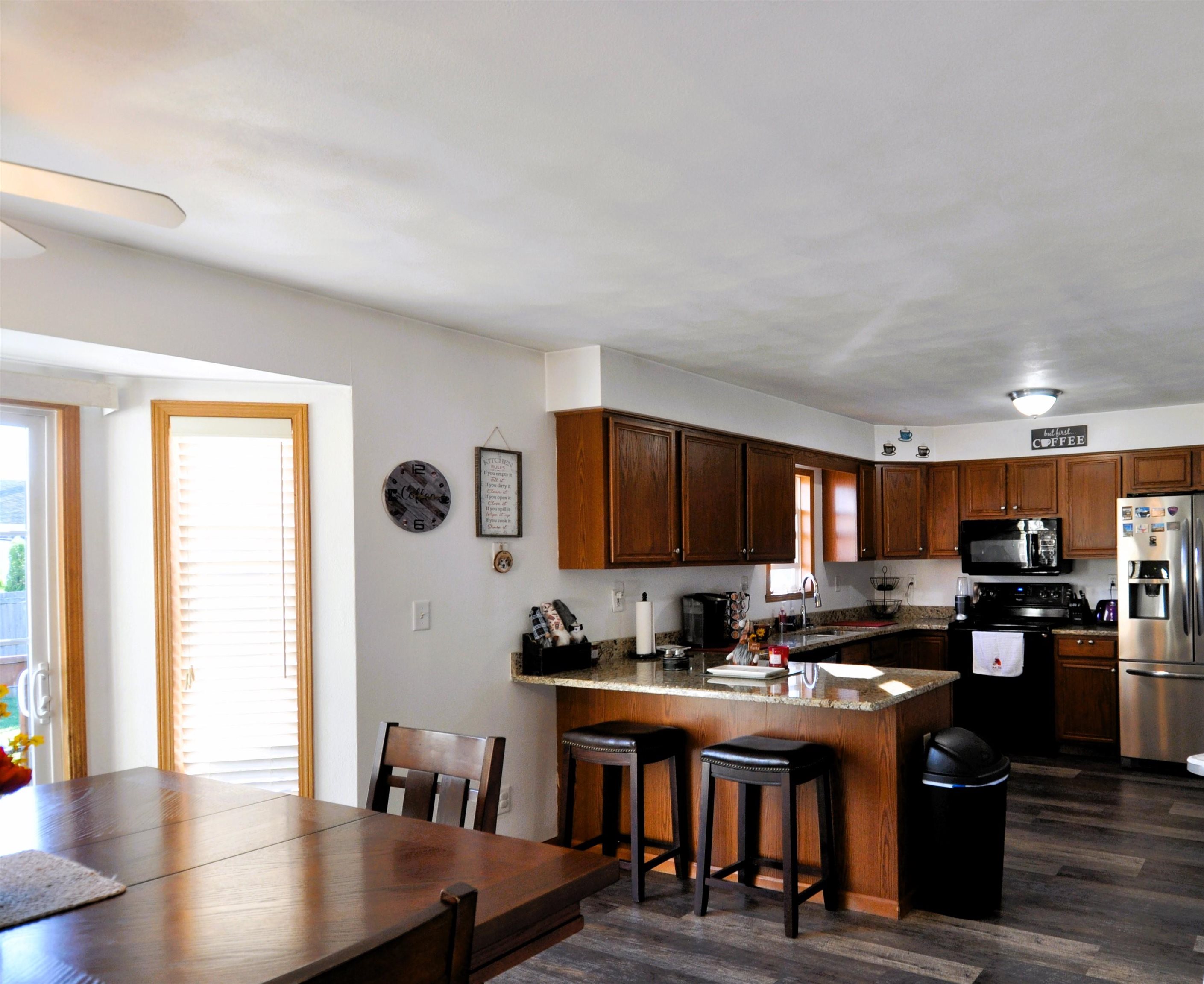 518 Merilot Drive Roscoe, IL 61073 - Photo 5 of 26 a kitchen with stainless steel appliances granite countertop a stove top oven a sink dishwasher and a microwave oven on the blue kitchen countertops with wooden floor