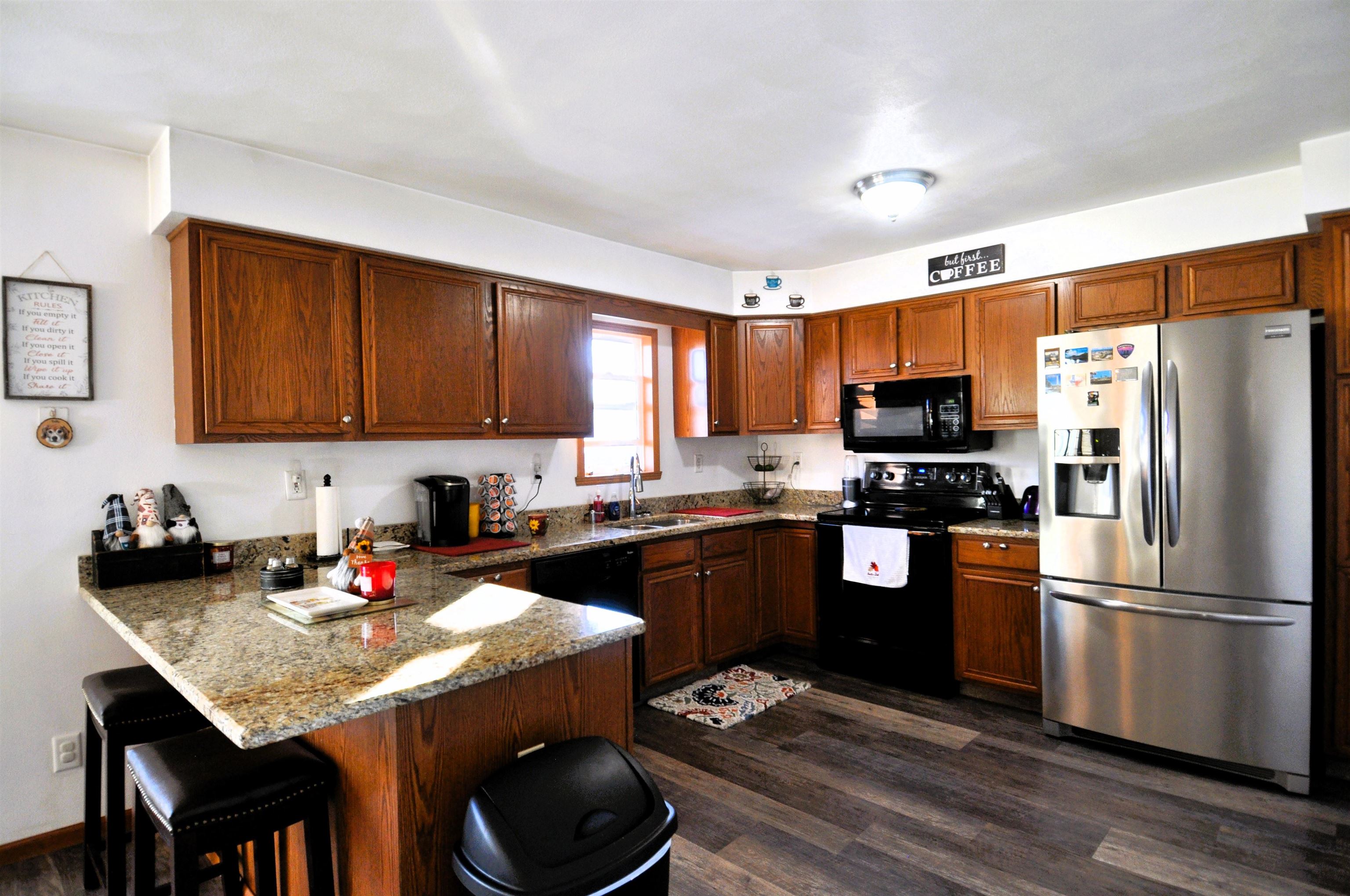 518 Merilot Drive Roscoe, IL 61073 - Photo 7 of 26 a kitchen with granite countertop a sink wooden cabinets and stainless steel appliances