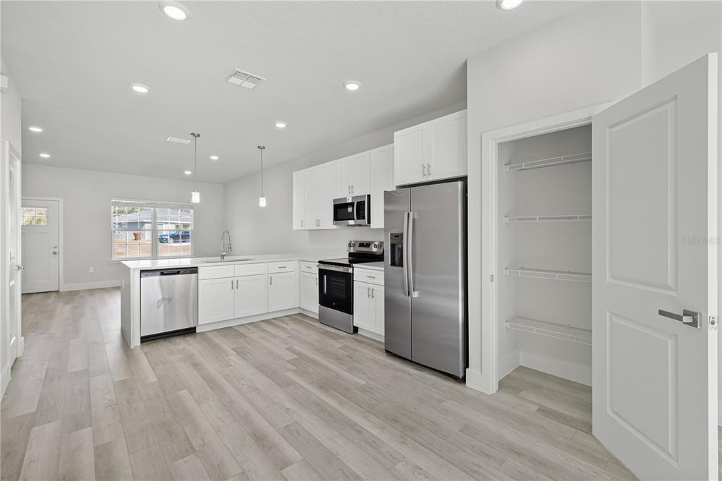 16082 Southwest 35th Court Road Ocala, FL 34473 - Photo 11 of 32 a kitchen with white cabinets and stainless steel appliances