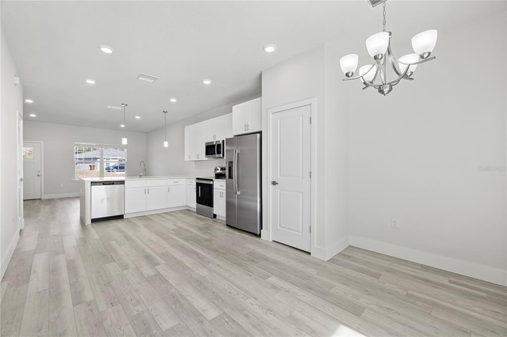 16082 Southwest 35th Court Road Ocala, FL 34473 - Photo 20 of 32 a view of a kitchen with a refrigerator wooden floor and a ceiling fan
