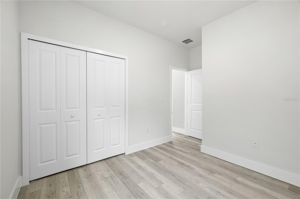 16082 Southwest 35th Court Road Ocala, FL 34473 - Photo 24 of 32 an empty room with wooden floor and closet area