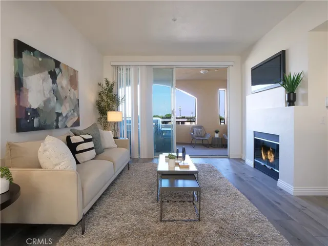a living room with furniture and a fireplace with wooden floor