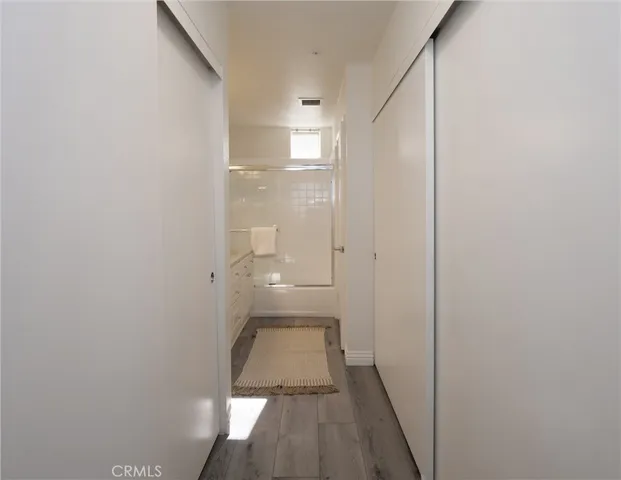 a view of a room with wooden floor and a bathroom