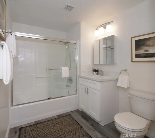 a bathroom with a sink a toilet a shower and a mirror